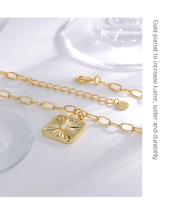 Detail view of gold plated necklace with sunflower pendant and opal stone inlay