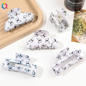 Detailed view of butterfly print hair claws in various shapes on a decorative tray