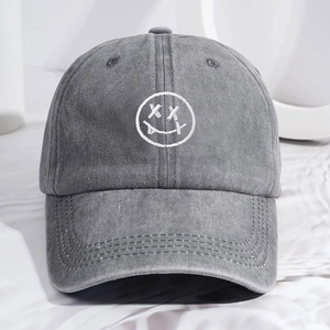 Faded grey washed denim baseball cap with white embroidered tongue-out smiley face