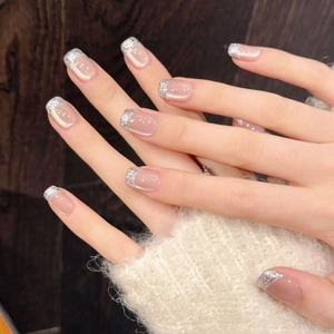 Short square nude pink press-on nails with silver glitter French tips and silk cat eye effect