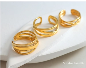 Detailed view of layered gold-tone titanium steel ring on textured aesthetic display
