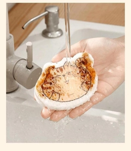 Macro detail of cat-shaped wood pulp cotton sponge absorbing water in the kitchen sink