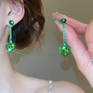 Detailed view of green heart zircon tassel earrings with elegant golden chain finish