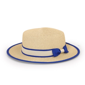 Close-up of the woven straw texture and navy blue ribbon bow on the sun hat brim