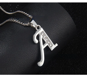 Macro detail of silver stainless steel letter A pendant with sparkling crystal inlays