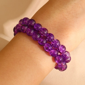 Dichtbij van de boheemse paarse kristallen kralen armband met craquelé textuur om de pols