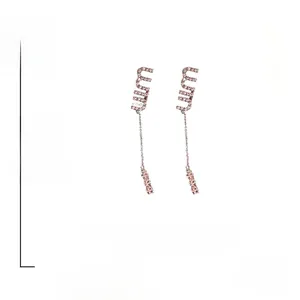 Detail view of long rose gold letter M earrings with pink rhinestones and S925 silver pins