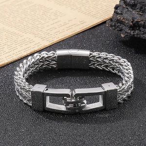 Close-up of silver titanium steel chain bracelet with magnetic clasp on black rock