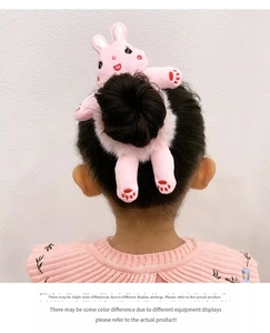 Chouchou lapin en peluche rose porté sur un chignon pour un accessoire mignon