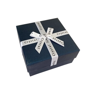 Detail of dark blue textured jewelry gift box with white Crystal Jewelry ribbon bow