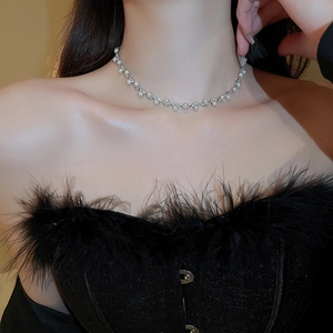 Elegant pearl and rhinestone necklace set worn by model on black feather dress outfit