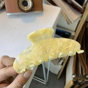 Large marbled yellow acetate hair claw clip with floral pattern for an elegant look