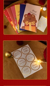 Close-up of festive Christmas cards and gold foil stickers with warm holiday decorations