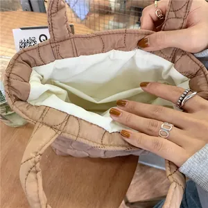 Detailed interior of quilted tote bag featuring white lining and inner pocket for storage