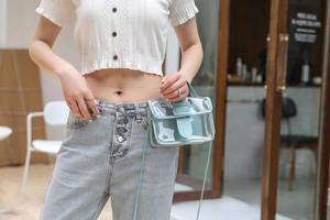 Close-up of summer clear PVC crossbody bag with light blue leather trim and strap