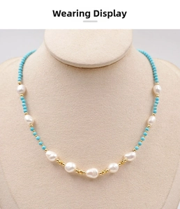 Close-up of baroque pearls and turquoise beads with gold flower charms on a necklace