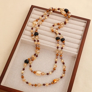 Detailed close-up of vintage multi-layer beaded necklace with amber and crystal beads