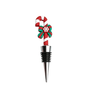 Detail view of a Christmas candy cane wine stopper with a red bow and silicone seal