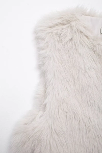 Macro detail of high-quality faux fur texture and soft silk lining on beige vest