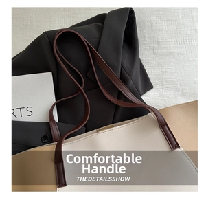 Detailed view of neutral colorblock tote bag on blazer showing stitch work and straps