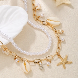 Layered beach style necklace with faux pearls, gold starfish charms and seashells