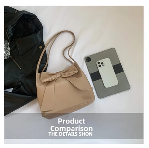 Detail showing high-capacity beige bow tote bag with dual shoulder straps and elegant texture