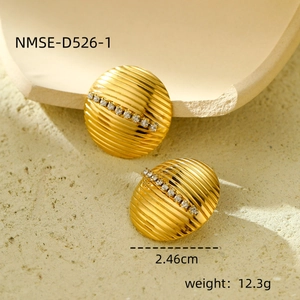 Gros plan de boucles d'oreilles dorées de 2,46 cm avec cristaux et détails rayés