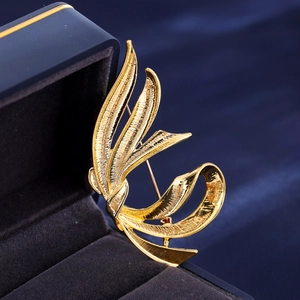 Detail of a vintage golden ribbon brooch on dark blue velvet in a premium jewelry box