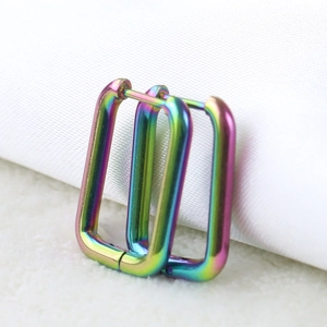 Close-up of rainbow gradient U-shaped stainless steel earrings with metallic finish