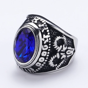 Vista macro de anillo punk con gema azul ovalada y relieves florales antiguos