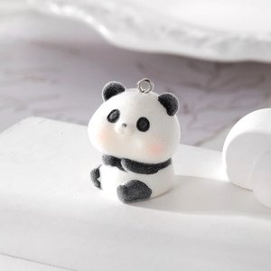 Macro shot of cute flocked panda pendant with soft texture and metal ring for DIY jewelry