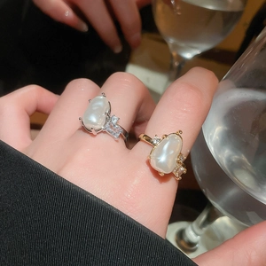 Lifestyle view of gold and silver irregular baroque pearl rings with zircon accents