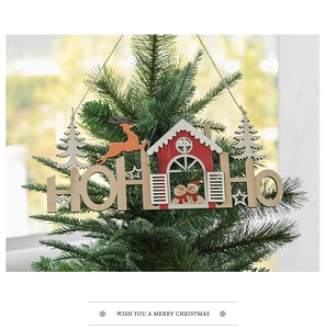 Close-up of wooden HO HO HO reindeer Christmas ornament hanging on a pine tree branch