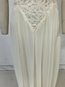 Detailed view of white floral lace patchwork and pleated fabric on summer dress