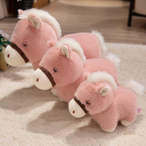 Trois peluches de cheval rose de tailles variées avec crinières blanches sur tapis doux