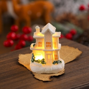 Macro shot of miniature white resin snow house with warm LED lighting and snow texture