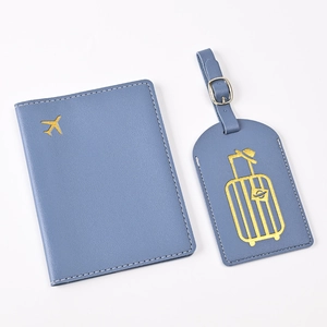 Flat lay of blue PU leather passport holder and luggage tag set with gold plane embroidery