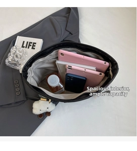 Spacious interior of black tote bag holding tablets, notebooks and a phone