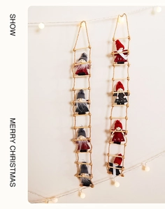 Close-up of wool felt Santa ornaments on a wooden ladder with warm festive lighting