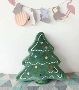 Detail of green velvet Christmas tree shaped pillow with colorful embroidery on fabric