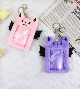 Detail of plush bat card holders in pink and purple with black wings and silver hooks