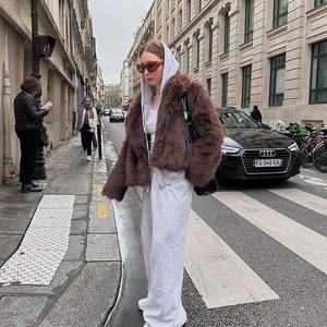 Deep brown faux fur coat paired with a grey hooded sweatshirt in a street style setting