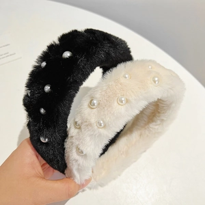 Detail of plush headbands in black and cream with decorative faux pearl embellishments