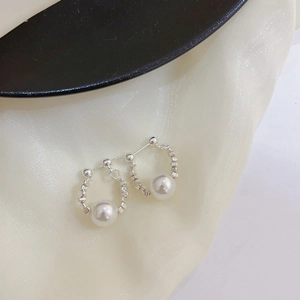 Close-up of S925 silver beaded hoop earrings with a single white pearl on silk background