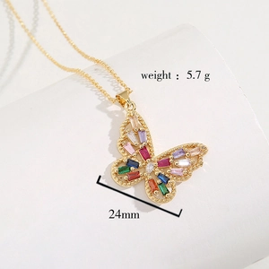 Détail macro du pendentif papillon doré avec pierres colorées, largeur 24mm et poids 5,7g
