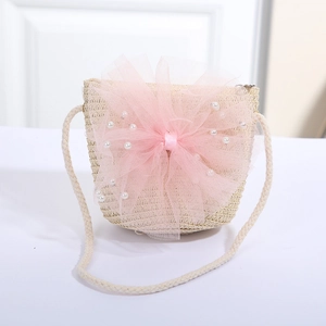 Detail der handgefertigten Stroh-Umhängetasche mit rosa Spitzenschleife und Perlen