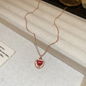 Dettaglio della collana a cuore in oro 18K con zircone rosso e intarsio in madreperla