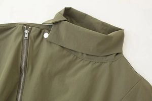 Détail d'une veste vert armée montrant le col montant, le zip et le bouton argenté