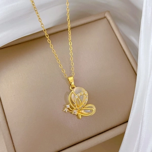 Detailed close-up of golden butterfly pendant with cat eye stone and sparkling crystals