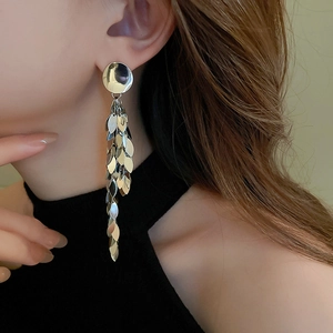Close-up of elegant silver tiered leaf fringe earrings worn by a model in a profile view